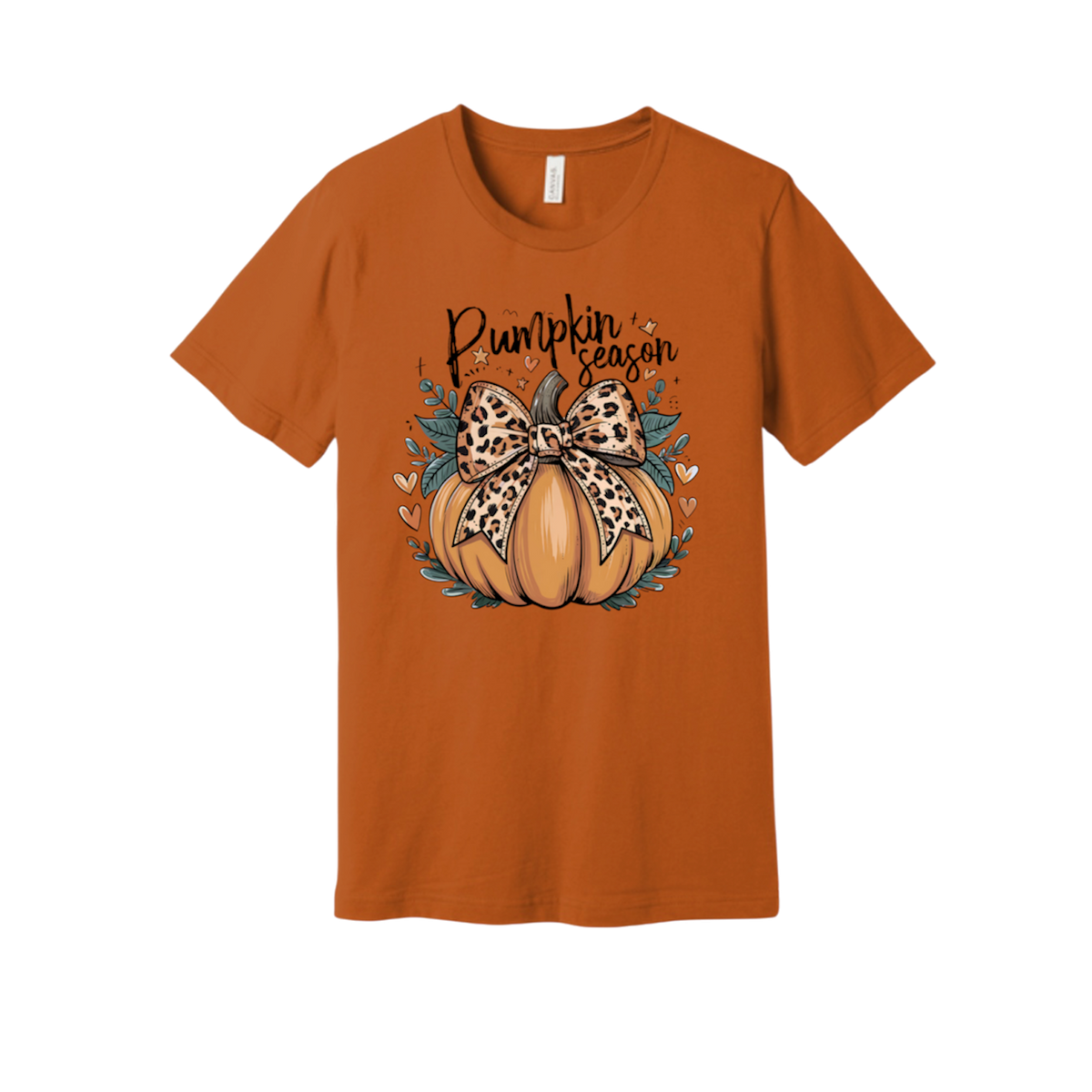 An orange short-sleeve crewneck t-shirt featuring a 'Pumpkin Season' graphic on the chest. The graphic depicts a cartoon pumpkin decorated with a leopard-print bow and surrounded by teal leaves and small hearts.